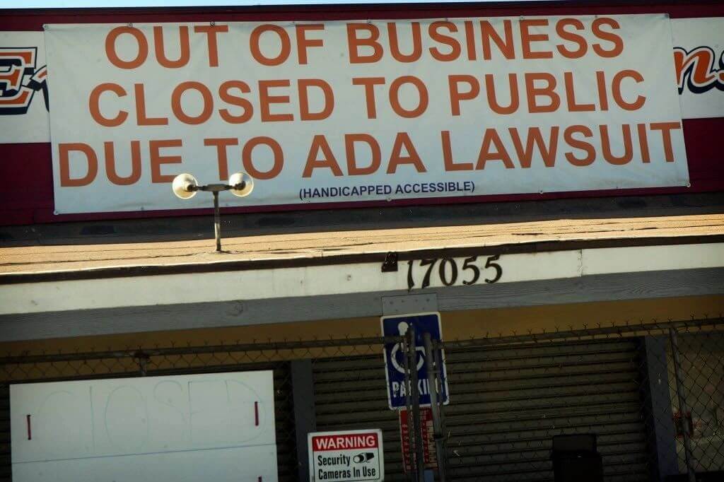 Closed storefront with a banner reading 'Out of business, closed to public due to ADA lawsuit'