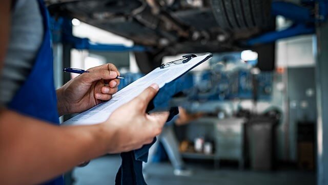 Inspector taking notes on a clipboard checklist during an on-site inspection