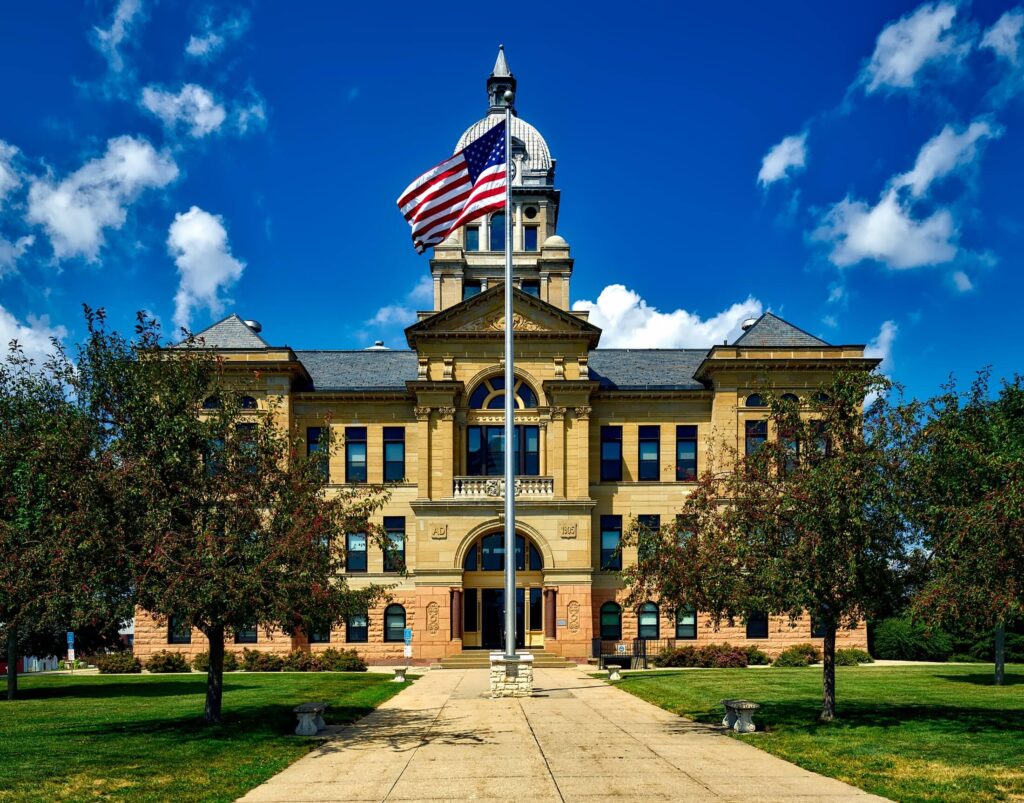 Courthouse building with an American flag, where ADA lawsuits against non-compliant properties are filed